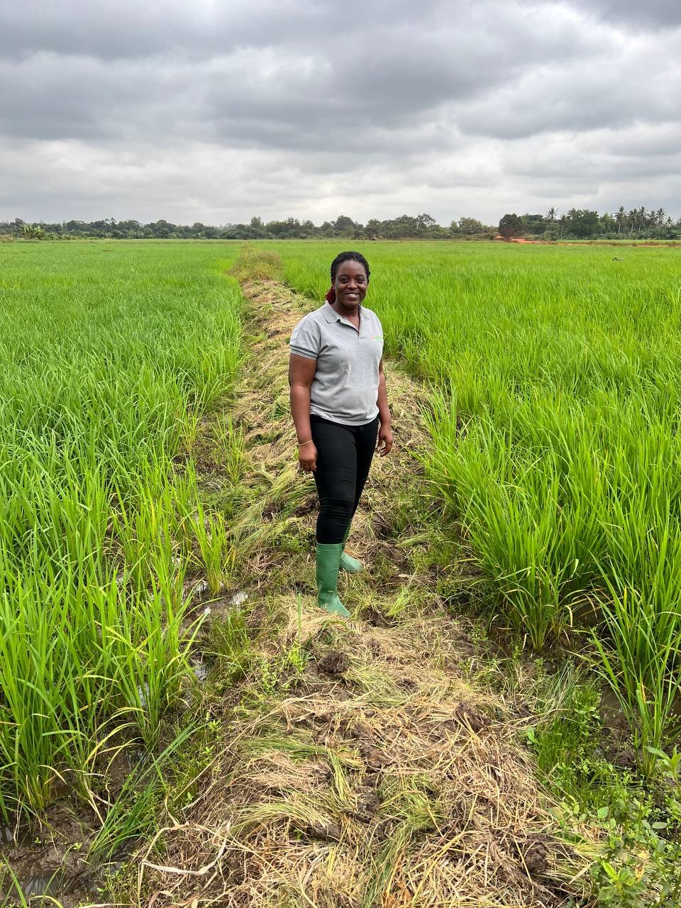 Diyana on a field visit in a green crop field